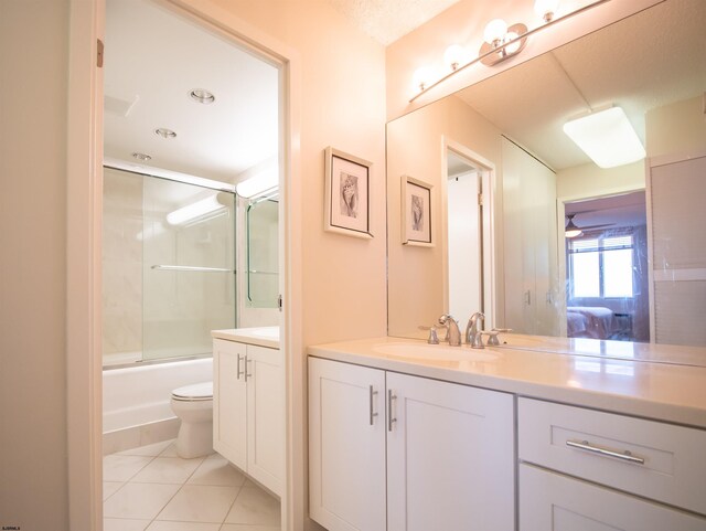 full bathroom with tile patterned floors, vanity, toilet, and enclosed tub / shower combo