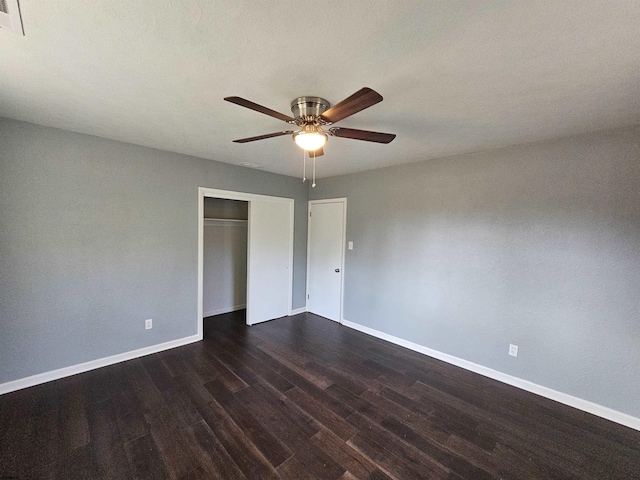 unfurnished bedroom featuring dark wood-type flooring, ceiling fan, and a closet