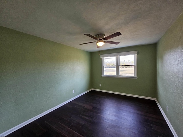 spare room featuring dark wood-type flooring and ceiling fan