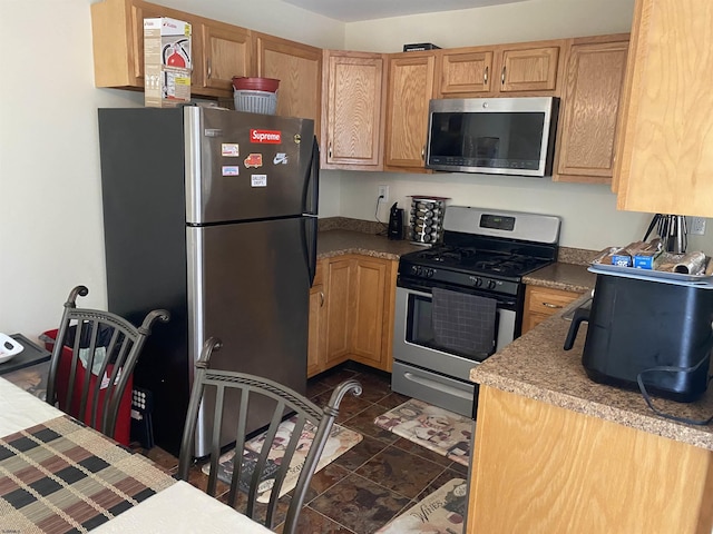 kitchen featuring dark tile patterned floors and appliances with stainless steel finishes