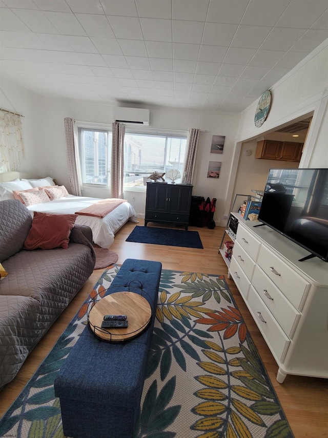 bedroom featuring a wall mounted AC and wood-type flooring