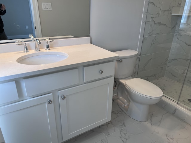 bathroom featuring tiled shower, vanity, and toilet