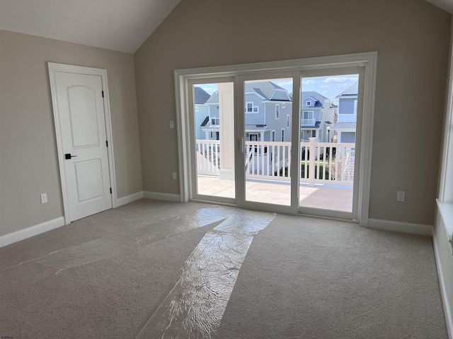 unfurnished room featuring light carpet and lofted ceiling