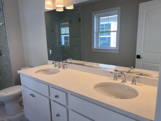 bathroom featuring vanity, toilet, and a shower with shower door