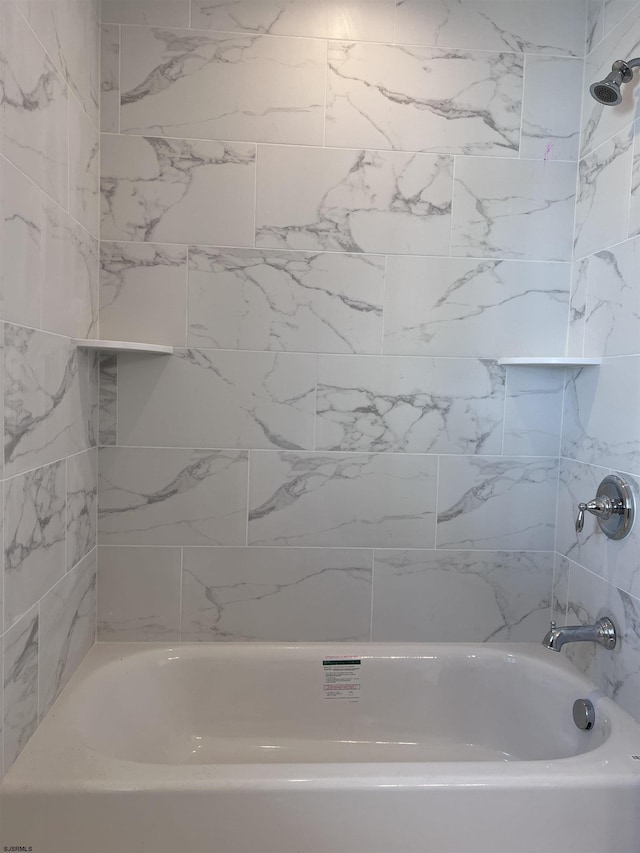 bathroom featuring tiled shower / bath