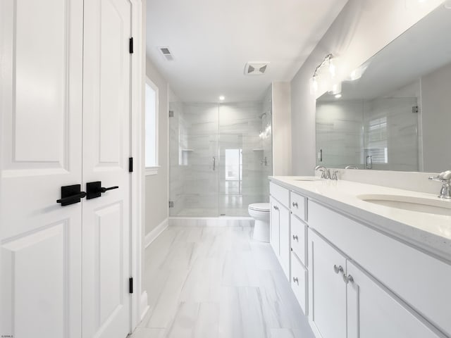 bathroom featuring vanity, toilet, and a shower with door