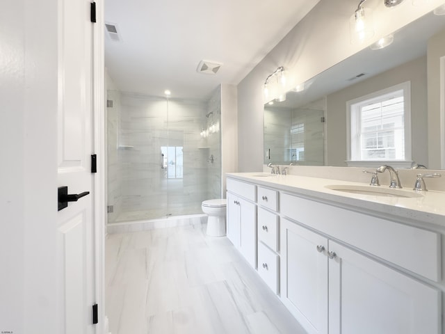 bathroom featuring vanity, toilet, and a shower with shower door