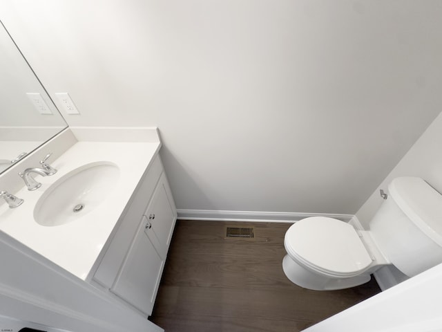 bathroom featuring hardwood / wood-style flooring, vanity, and toilet