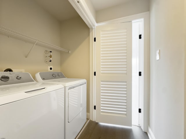 clothes washing area featuring dark hardwood / wood-style flooring and washer and clothes dryer