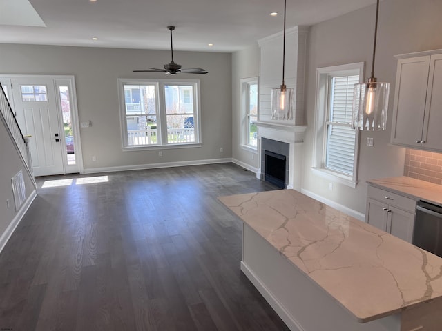 kitchen featuring pendant lighting, a center island, dark wood-type flooring, tasteful backsplash, and white cabinetry