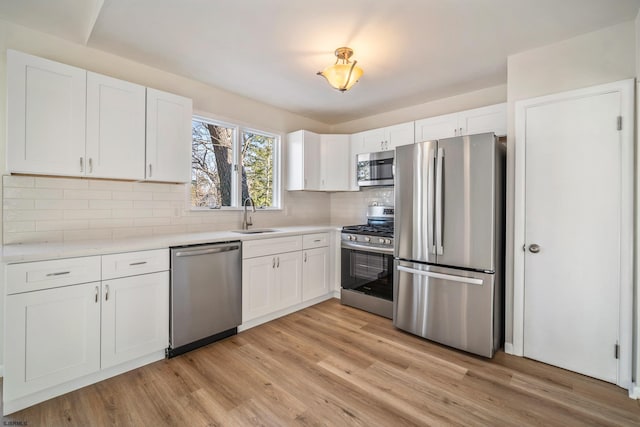 kitchen featuring white cabinets, decorative backsplash, sink, and appliances with stainless steel finishes