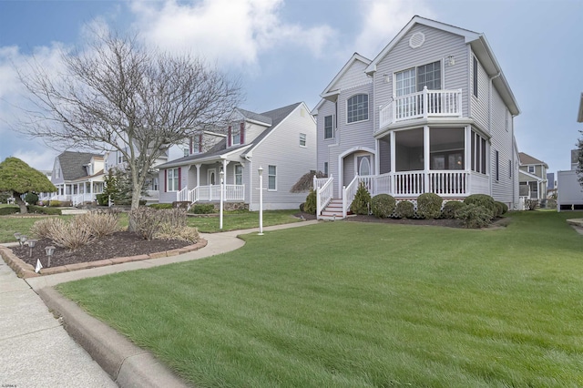 view of front of house with a balcony and a front yard