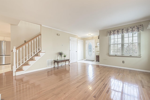 entrance foyer featuring light hardwood / wood-style floors and crown molding