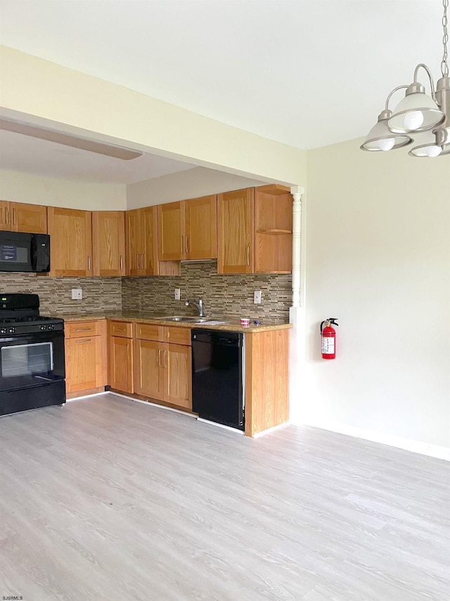 kitchen with sink, pendant lighting, decorative backsplash, black appliances, and light wood-type flooring