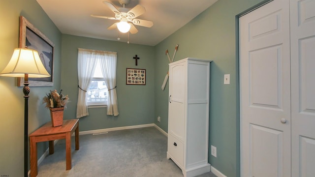 interior space featuring ceiling fan and light colored carpet