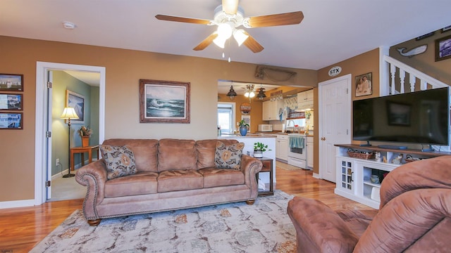 living room featuring ceiling fan and light wood-type flooring