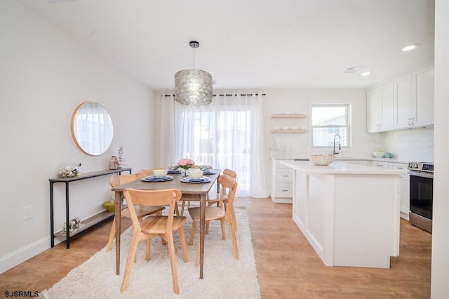 dining area with light hardwood / wood-style flooring and sink