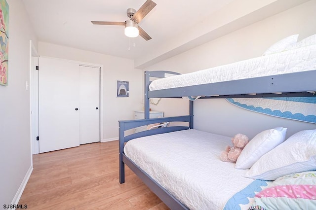 bedroom featuring ceiling fan, light wood-type flooring, and a closet