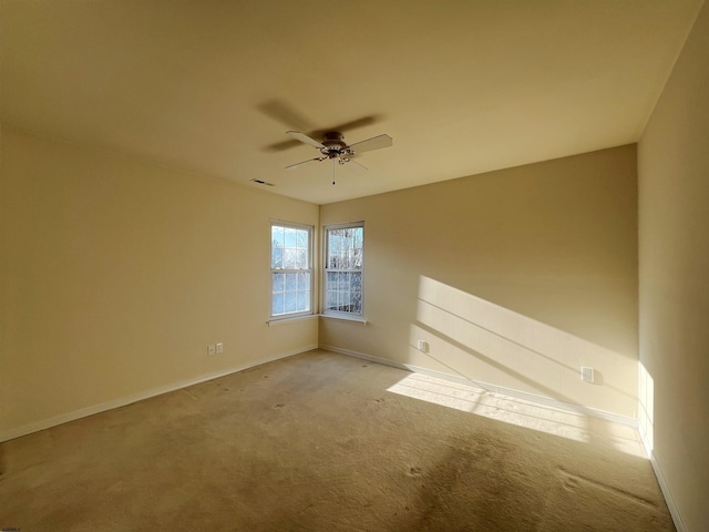 spare room featuring ceiling fan and light carpet