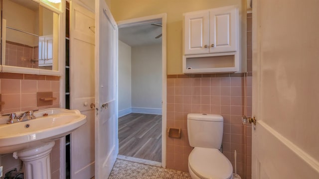 bathroom with sink, toilet, tile walls, and hardwood / wood-style flooring