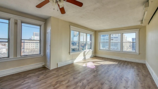 interior space with hardwood / wood-style flooring, baseboard heating, and ceiling fan