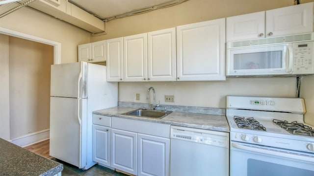 kitchen featuring white appliances, white cabinetry, and sink