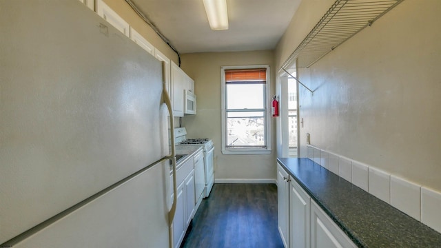 kitchen with white appliances, dark hardwood / wood-style floors, and white cabinetry