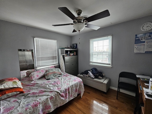 bedroom with dark wood finished floors, a ceiling fan, and baseboards