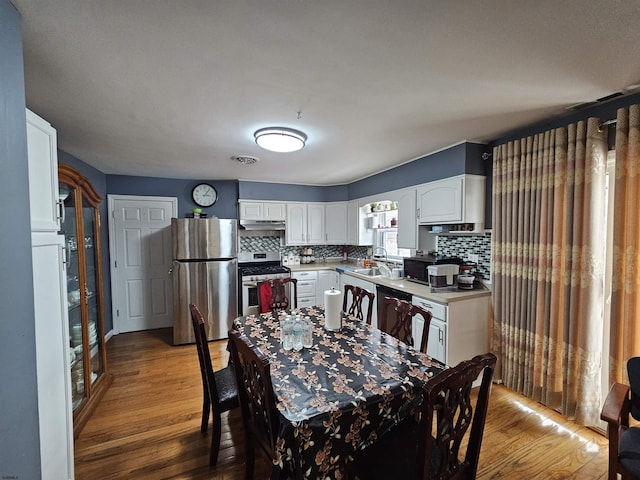 kitchen with light countertops, visible vents, appliances with stainless steel finishes, white cabinets, and a sink