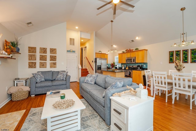 living room with ceiling fan, light hardwood / wood-style flooring, and high vaulted ceiling