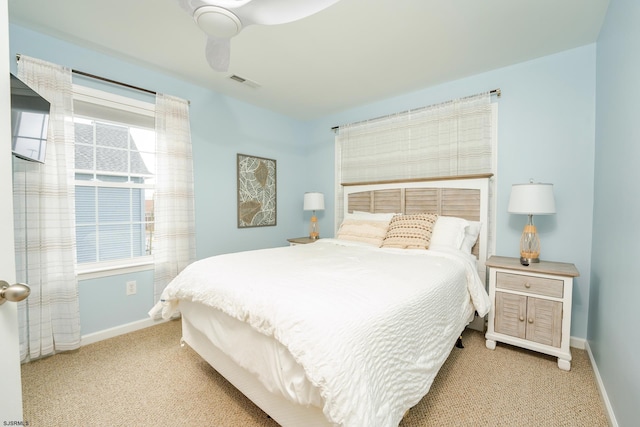 carpeted bedroom featuring multiple windows and ceiling fan