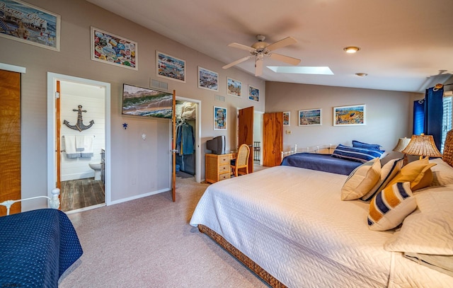 carpeted bedroom with ensuite bath, ceiling fan, a closet, and lofted ceiling with skylight