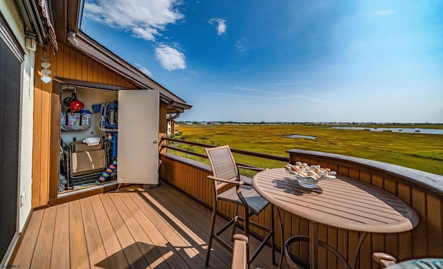 wooden deck with a water view and a rural view