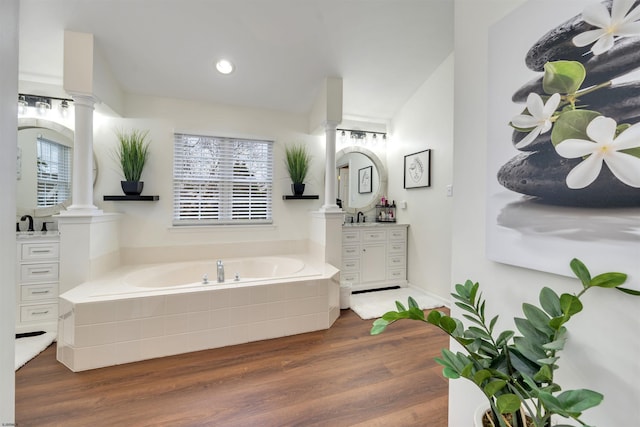 bathroom featuring vanity, tiled bath, and hardwood / wood-style flooring