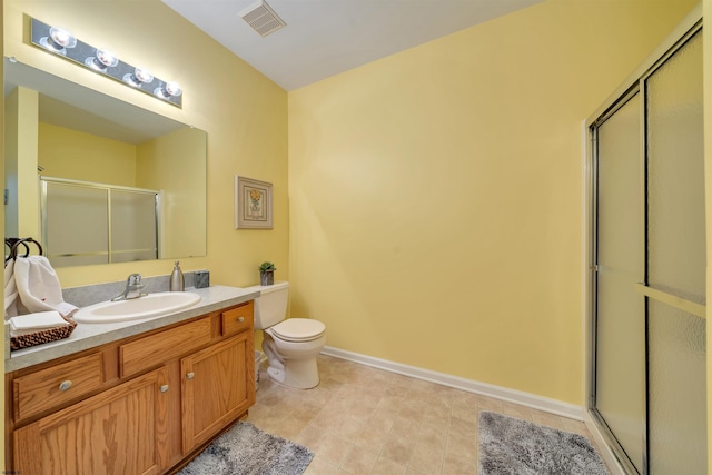 bathroom featuring vanity, toilet, and a shower with shower door