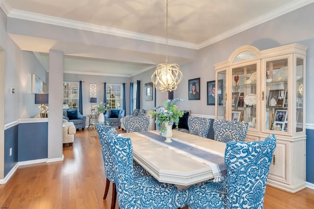 dining area featuring light hardwood / wood-style flooring, crown molding, and a chandelier