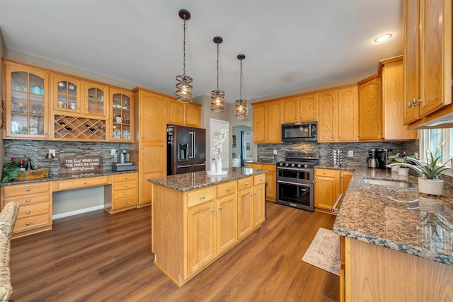 kitchen with stainless steel electric range, hanging light fixtures, sink, high quality fridge, and a kitchen island