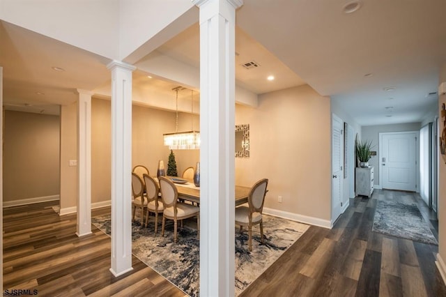 dining space with dark wood-type flooring and decorative columns