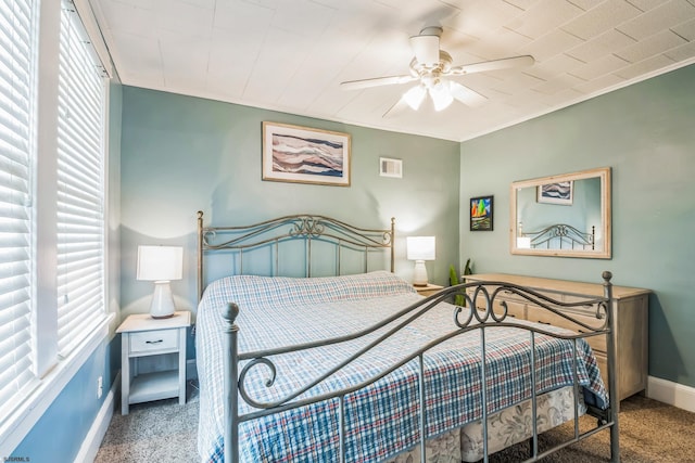 carpeted bedroom with multiple windows and ceiling fan