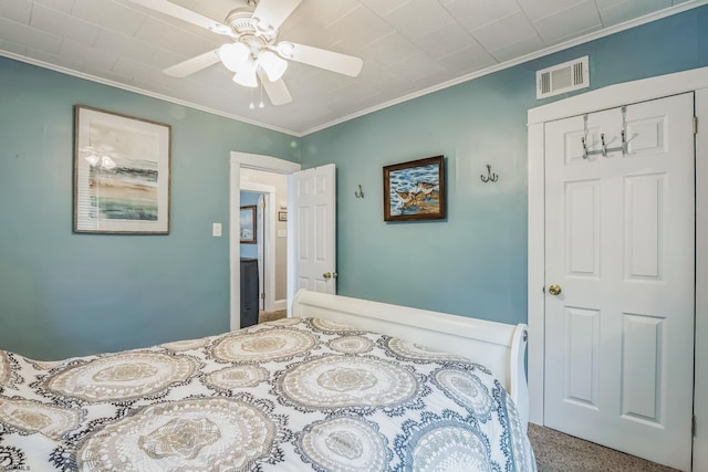 bedroom featuring a closet, ceiling fan, crown molding, and carpet floors