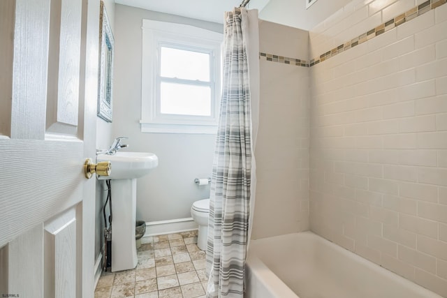 full bathroom with sink, shower / bathtub combination with curtain, and toilet