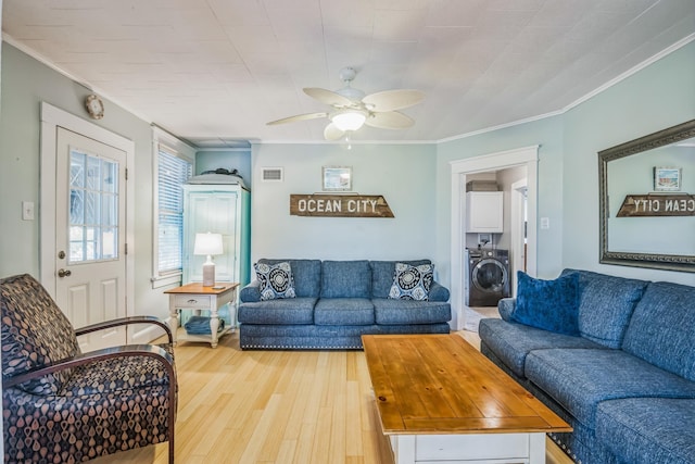 living room featuring washer / clothes dryer, light hardwood / wood-style flooring, ceiling fan, and ornamental molding