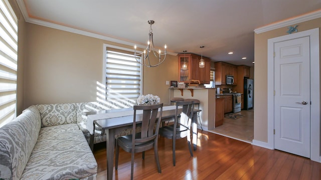 dining room featuring ornamental molding, a notable chandelier, and hardwood / wood-style flooring