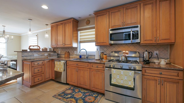 kitchen featuring sink, an inviting chandelier, tasteful backsplash, decorative light fixtures, and appliances with stainless steel finishes