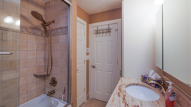 bathroom featuring tiled shower / bath combo and vanity