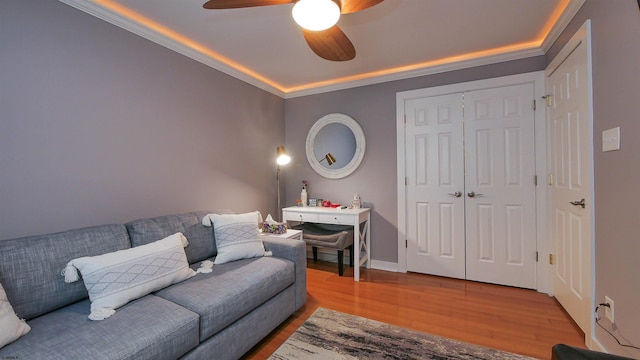 living room with hardwood / wood-style flooring, ceiling fan, and crown molding