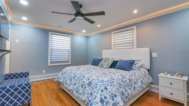 bedroom featuring hardwood / wood-style flooring, ceiling fan, crown molding, and baseboard heating