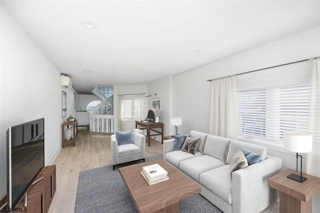 living room with light hardwood / wood-style flooring and a wall mounted AC