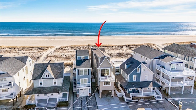 drone / aerial view featuring a water view and a beach view