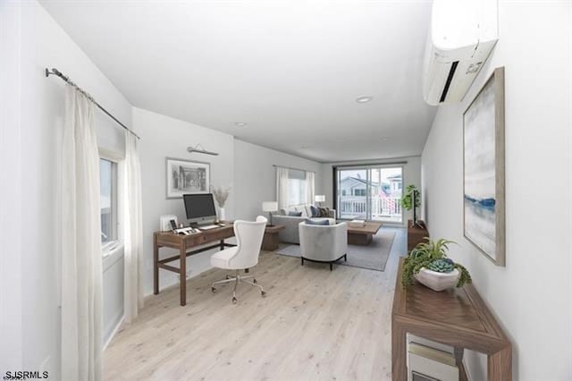 office featuring a wall mounted air conditioner and light hardwood / wood-style floors